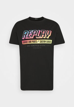 Černé bavlněné tričko s krátkým rukávem, na kterém je vícebarevný text: "REPLAY SERVICE AND PARTS CUSTOM GARAGE" a "THE MOTORCYCLE ENTHUSIAST."