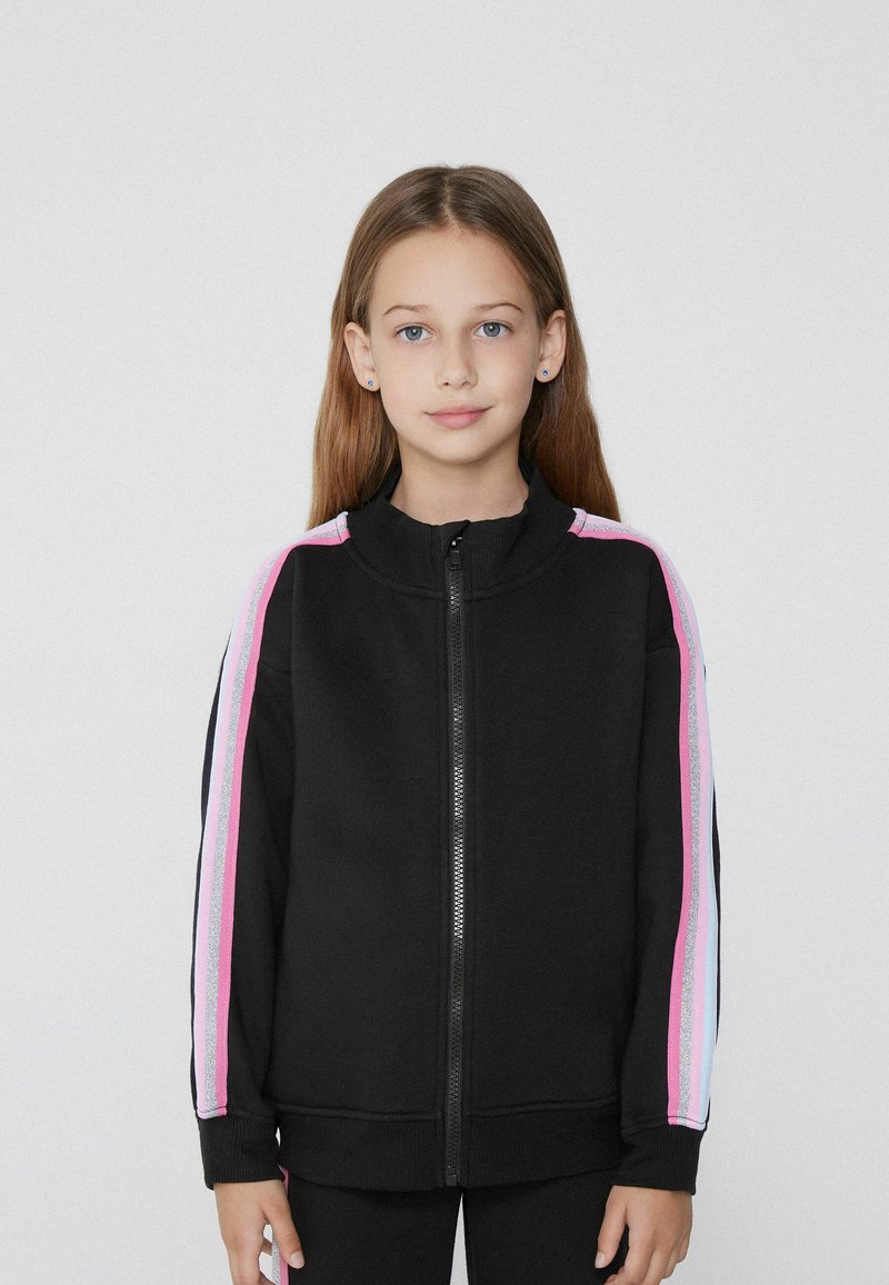 Giacca nera a zip con colletto alto, caratterizzata da accentuazioni a strisce rosa e argento sulle maniche. Realizzata in un tessuto dalla texture liscia.