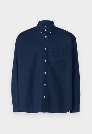 Marineblå knap-op skjorte lavet af bomuld. Har en spids krave, lange ærmer, en brystlomme og hvide knapper. Tekstureret stof.
