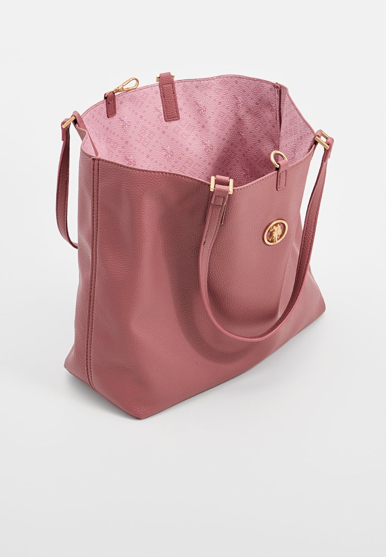 Bolsa de tote de cuero texturizado en rosa claro con herrajes en tono dorado y un interior de un rosa claro contrastante. Cuenta con dos asas para el hombro.