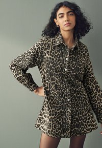 Rochie cămașă cu imprimeu leopard, cu nasturi, guler și mâneci lungi. Fabricată dintr-un material moale, având o croială lejeră și două buzunare frontale.