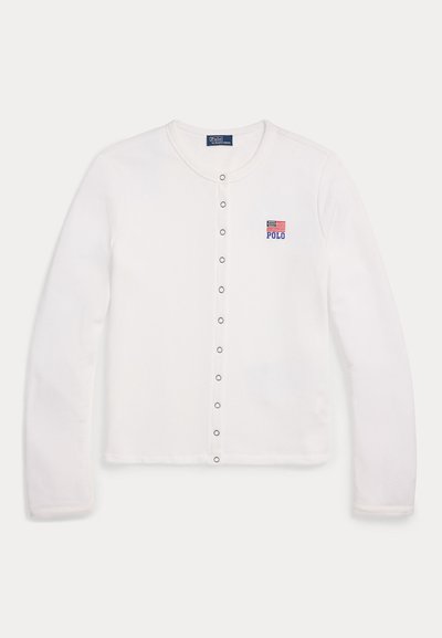 Valge pika varrukaga kardigan, mis on valmistatud puuvillast, ümar kaelus, nööpidega kinnitamine ja väike tikand, millel on Ameerika lipp.
