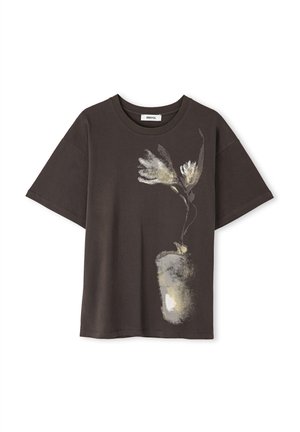 Donkerbruin katoenen T-shirt met korte mouwen, voorzien van een lichtgekleurde bloemenprint op de voorkant. Ronde halslijn en een relaxte pasvorm.