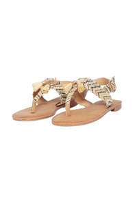 Sandali piatti intrecciati con una suola in pelle color tan. La parte superiore presenta motivi a zigzag neri e beige, adornati con frange beige e dettagli in oro.