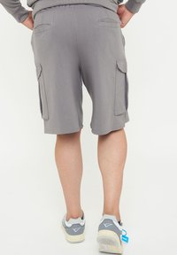 Grå cargoshorts med avslappnad passform, elastisk midja och flera sidofickor. Mjuk material, knälång skärning och platta sömmar.