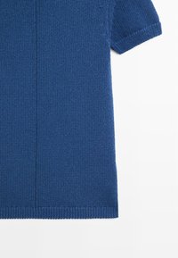 Pull court à manches courtes tricoté bleu avec bords côtelés et détail de couture verticale au centre sur fond blanc.