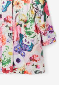 Veste légère à motif floral en rose pastel, avec des accents verts et bleus, taille élastique et deux poches latérales.