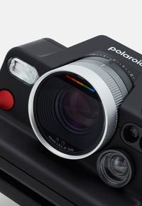 Polaroid camera featuring a matte black body, silver lens housing, and red button. Includes a flash and a distinctive rainbow color accent.