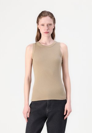 Beige ribbed sleeveless top with a crew neckline, featuring a fitted silhouette. Pairing with dark denim jeans, showcasing a smooth texture.