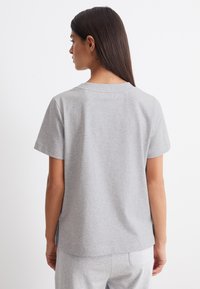Grijze katoenen T-shirt met korte mouwen, ronde halslijn en zijsplitten aan de onderkant, met een soepele textuur en een casual pasvorm.
