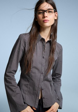 Striped button-up shirt in dark gray with light gray vertical stripes, featuring a classic collar, long flared sleeves, and button details.