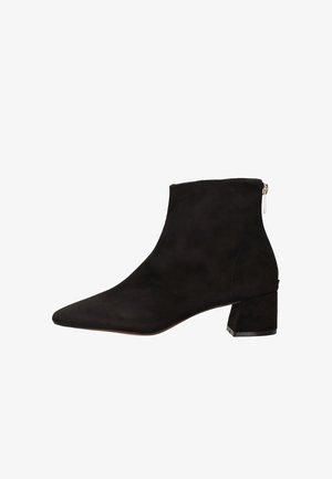 Bota de tobillo de ante negro con punta puntiaguda y tacón bloque con acabado texturizado. Cremallera lateral para facilitar su uso. Sin patrones visibles.