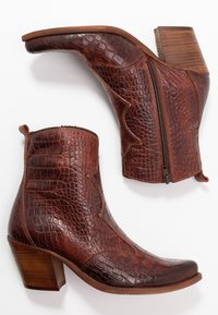 Bruna läderankelstövlar med en texturerad, krokodilskinnsdesign, sidodragkedja, spetsig tå och en kraftig träklack.