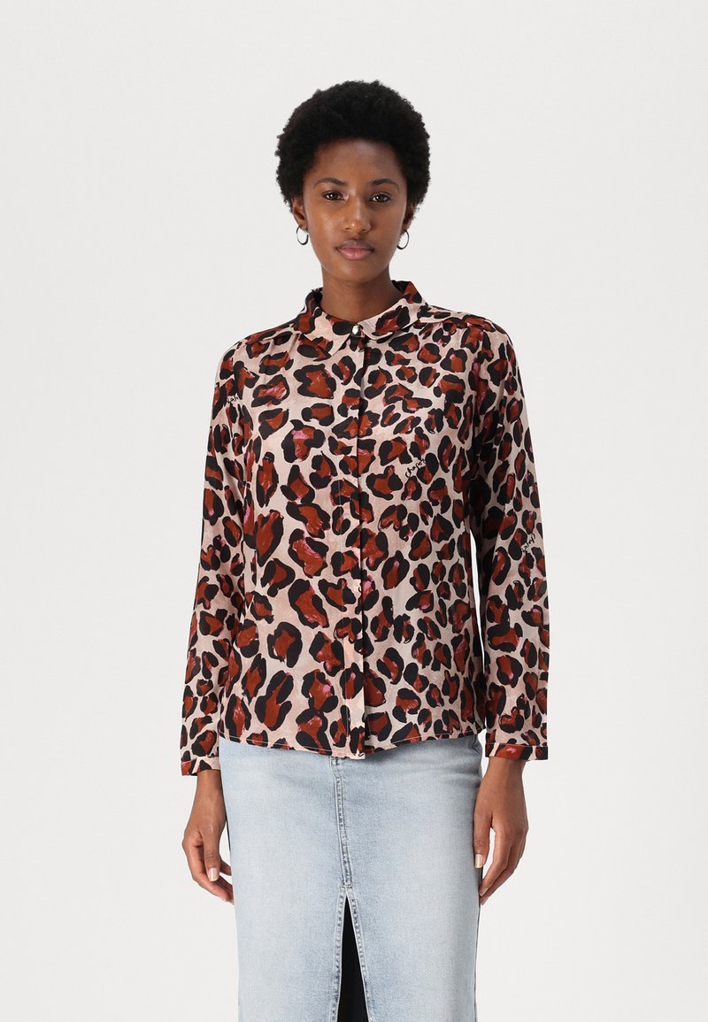 Leopard print shirt featuring a light pink background with black and red spots, long sleeves, button front, and a collar.