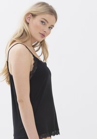 Camisola nera con spalline sottili, bordo in pizzo lungo lo scollo e l'orlo, caratterizzata da un tessuto morbido e una vestibilità comoda.