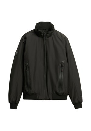 Zwarte zip-up jack met een hoge kraag, gestructureerd oppervlak, ribgebreide manchetten en twee rits-zijzakken. Gevuld met een ronde logo op de mouw.