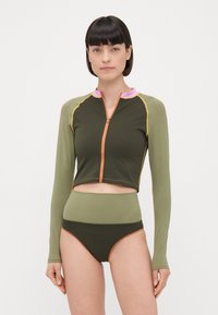 Top da piscina a maniche lunghe di colore verde scuro con zip arancione, colletto rosa e cuciture gialle a contrasto; abbinato a un bikini bottom verde scuro a vita alta.