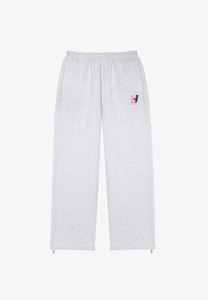 Jasnoszare dresy wykonane z miękkiego materiału, z elastycznym pasem, prostymi nogawkami oraz małym logo w różowym i czarnym kolorze po boku.