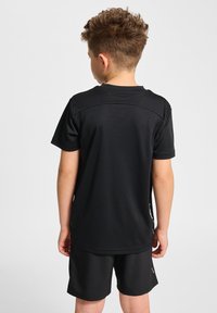 T-shirt de sport noir à manches courtes, fabriqué en matériau respirant. Présente un col rond et une texture lisse. Associé à un short assorti.