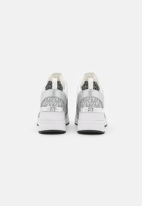 Sneakers bianchi con accenti argentati, caratterizzati da una parte posteriore decorata, una tomaia in morbido tessuto e una suola bianca spessa.
