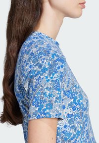 Short-sleeve T-shirt made of lightweight fabric featuring a blue floral pattern with varying shades, a round neckline, and a fitted silhouette.
