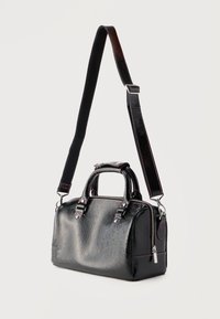 Μαύρη τσάντα από πατενταρισμένο δέρμα με υφή, δύο επάνω λαβές, αποσπώμενο μακρύ λουρί ώμου και ασημένιο φερμουάρ κλεισίματος.