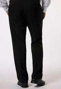 Pantalones negros ajustados con un diseño de pierna recta, que cuentan con bolsillos laterales y bolsillos traseros con botón, llevados con zapatos negros.