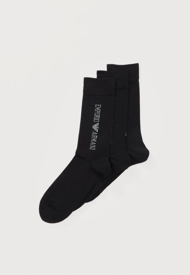 Τρία ζευγάρια μαύρες κάλτσες πλήρους μήκους στοιβαγμένα, με το λευκό λογότυπο "EMPORIO ARMANI" στην πλευρά του πάνω ζευγαριού.