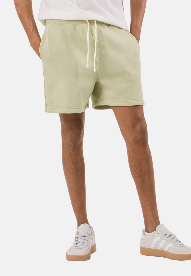 Lichtgroene katoenen korte broek met een elastische tailleband en verstelbare trekkoord, voorzien van zijzakken en een ontspannen pasvorm.