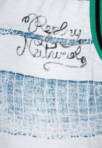 Tissu blanc avec un motif de grille texturé bleu et un texte en cursif "Ready Natural" brodé en noir, bordé de finitions vertes et noires.