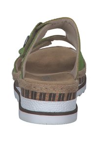 Grøn sandal med justerbar strop, kork-sål, teksturerede såler og en slidt hvid- og sortstribet ydersål. Bagfra ses det åbne design.