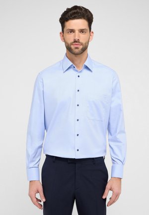 Himmelblaues Hemd mit Knopfleiste aus gewebtem Stoff, ausgestattet mit einem spitzen Kragen, langen Ärmeln und einer Brusttasche. Dunkle Knöpfe kontrastieren mit dem Stoff.