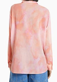 Lichte lange-sleeve shirt in het roze met een tie-dye patroon. Heeft een kraag, knoopmanchetten en een gestructureerde stof.