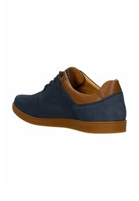 Scarpe in pelle blu navy con un accento in pelle marrone sul tallone, caratterizzate da una punta tonda, lacci e una suola in gomma. Trama liscia nel complesso.