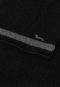 Maglione nero lavorato a maglia con una striscia orizzontale grigia e un logo ricamato di bassotto vicino all'orlo. Texture morbida e design casual.
