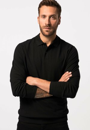 Camisa polo negra de manga larga con cuello y puños acanalados, que presenta un sutil logotipo en el pecho. Textura suave, silueta ajustada.