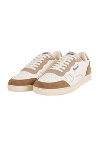 Un paio di sneakers bianche e beige a basso profilo con punte perforate, chiusura con lacci e toppe con il logo del marchio sui lati e sulle linguette.