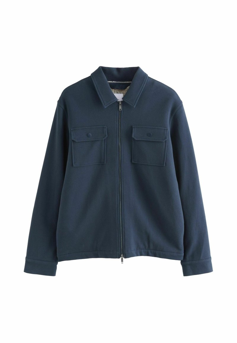Námornícky modrá zipsová bunda z mäkkého, texturovaného materiálu, s golierom a dvoma prednými vreckami so zapínaním na gombíky.
