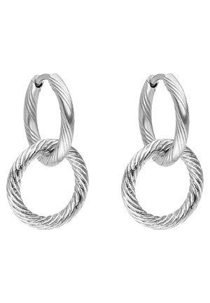 Silberne, verdrehte Doppelkreolen mit einem kleineren Ring, der mit einem größeren, strukturierten Ring verbunden ist, dargestellt auf weißem Hintergrund.