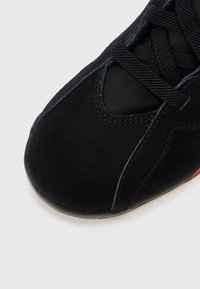 Μαύρο αθλητικό παπούτσι με λείο σουέτ φινίρισμα, με στρογγυλεμένη μύτη, ραμμένες λεπτομέρειες και υφασμένα κορδόνια. Η σόλα είναι από λάστιχο με ελαφριά αντίθεση χρωμάτων.