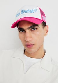 Weißes und pinkfarbenes Mesh-Cap mit "Von Dutch Originals" in Blau gestickt. Mit einem gebogenen Schirm und einem strukturierten Vorderteil.