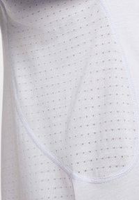 Camiseta atlética blanca con un panel de malla texturizada con pequeños puntos, tela suave y acentos de costura en contraste.