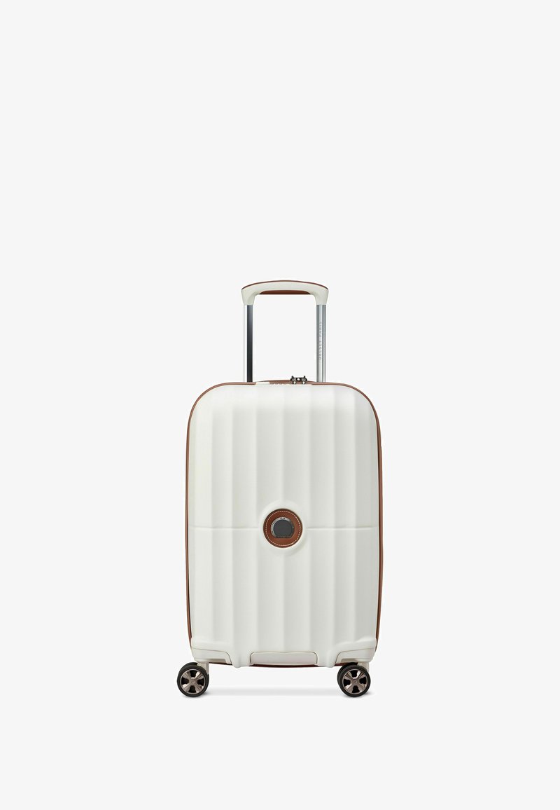 Witte hardshell koffer met verticale ribbelstructuur, bruine accenten, uitschuifbare handgreep en vier draaiwielen voor mobiliteit.