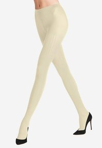Collant beige a coste con finitura liscia, caratterizzati da una vita alta e un design elegante abbinato a scarpe con tacco nero.