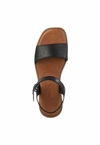 Black strappy sandal with a wide band across the vamp and adjustable ankle strap, featuring a tan-colored footbed and smooth texture.