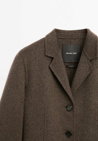 Brown wool coat with a notched collar, three black buttons, and textured fabric. Label visible inside with brand name "Massimo Dutti."