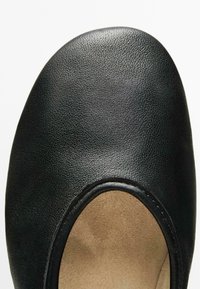 Schwarze Lederschuhe mit runder Zehenform und glatter Oberfläche. Verfügt über ein Ausschnittdesign und ein hellbraunes Innenfutter mit sichtbaren Nähten.