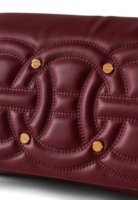 Burgunderfarbene Leder-Clutch mit gestepptem Design, geschwungenen Mustern, dezenten goldfarbenen Hardware-Akzenten und kontrastierenden Nähdetails.