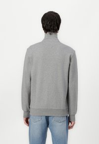 Gray, high-neck sweatshirt with long sleeves and ribbed cuffs, made of soft material. Features a relaxed fit and solid color design.