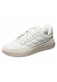 Sneakers bianchi in pelle liscia con pannelli laterali testurizzati, caratterizzati da una punta arrotondata, chiusura a lacci e una suola in gomma di colore chiaro.